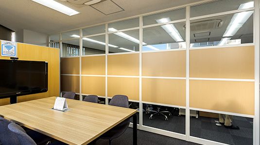 木目にガラスパーテーションを組み合わせた明るい会議室
