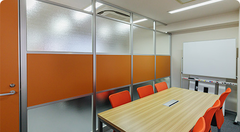 コーポレートカラーをパネルに採用したソフト開発会社の会議室